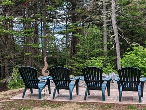 Relax at the stone fire pit and see the bay through the screen of trees 🌲