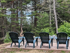 Relax at the stone fire pit and see the bay through the screen of trees 🌲