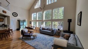 Open-concept living space overlooking woods with 3/4 covered wrap-around deck