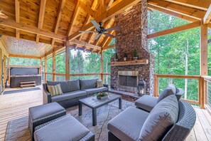 Amazing stone fireplace with the lit beams overhead and the view of the forest 