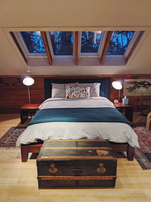 A dreamy bed with a view into the trees.