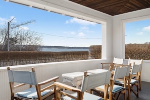 After a day at the beach, or a round of golf, unwind on the perfect porch, facing the sea - and sunsets! Views from the entire wraparound porch. Dining table for 8, sofas, a chaise and many captains chairs await. You will never want to leave!