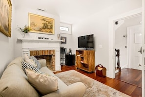 A historic fireplace welcomes you to the front room of The Gallery Suite. 