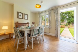 1 Hall Lane Cottages, Thornham: Entrance in to dining room with open fire, seating for six and wooden floor