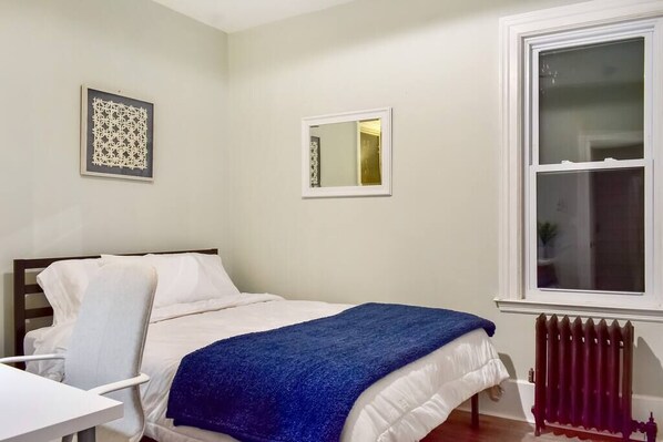 The rear bedroom features a dresser, desk, queen bed, and large closet