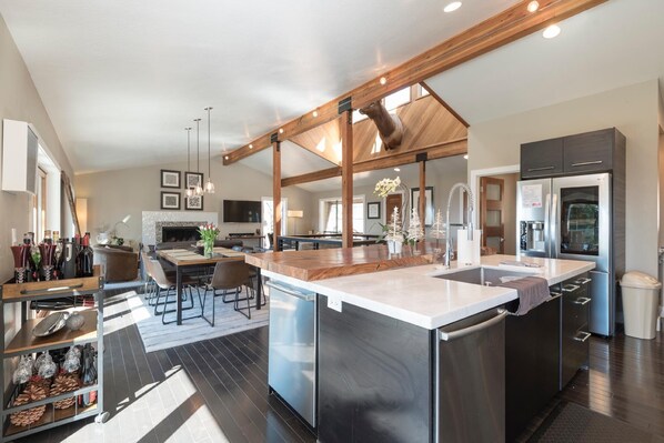 High-end, modern kitchen w/ stainless steel amenities, unique granite wood counters, and lots of space.