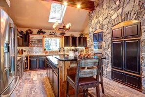 Kitchen with stainless steel appliances, granite countertops, and breakfast bar seating.