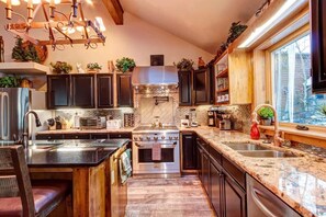 Kitchen with stainless steel appliances, granite countertops, and breakfast bar seating.
