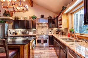 Kitchen with stainless steel appliances, granite countertops, and breakfast bar seating.