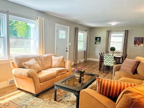 Large family room, 65" smart TV & comfortable sofas, expands into dining room.
