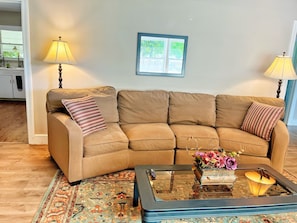 Large family room, 65" smart TV & comfortable sofas, expands into dining room.