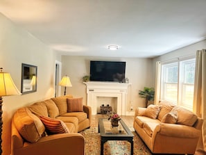 Large family room, 65" smart TV & comfortable sofas, expands into dining room.