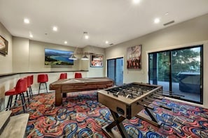 70 inch Tv on Game Room true for Sports enthusiast Foosball and Pool Table. Bar stools perfect for entertainment and fun 