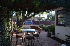 Private patio shaded with trumpet vines and jasmine flowers