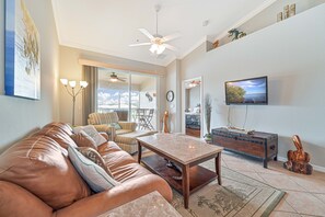 BT1426 - Living with comfortable seating and flat screen TV. Sliding doors open up to the screened in lanai with lake view! The couch is a full size pull out sofa
