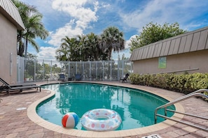 Heated community pool (no BBQ) with loungers & tables just steps from the condo.