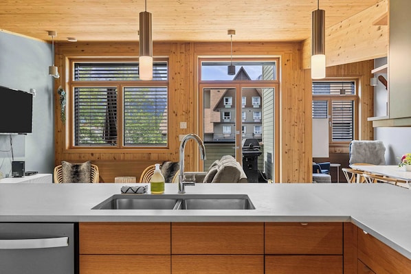 Beautifully styled kitchen overlooking the open plan living and dining area, out onto the south-facing deck