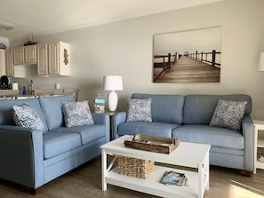 Living room with new couches to relax on & look out at the ocean or watch TV.