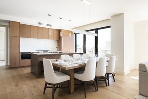 Expansive dining room, solid wood table with seating for 8 in high back upholstered chairs, hardwood floors throughout