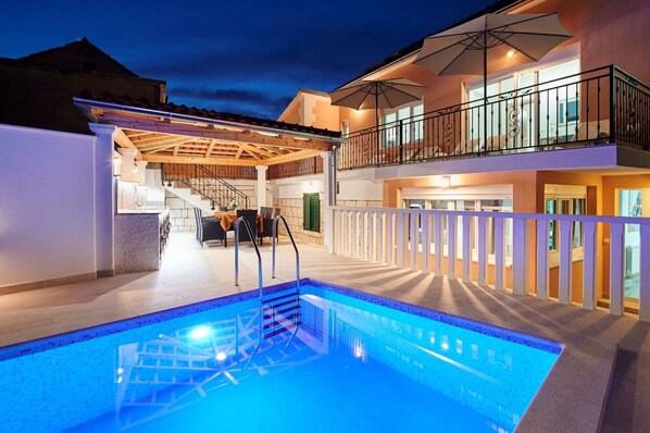 Front of the house by night- lighted pool