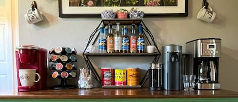 Drip-pot, Keurig, & a Nespresso machine along with assorted syrups and creamers.