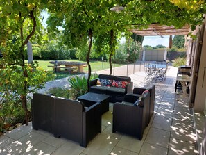 La terrasse principale à l'ombre d'une vigne