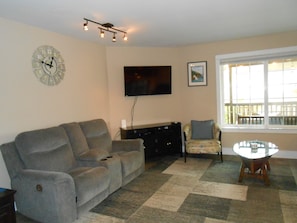 Living room with reclining love seat & couch. large flat screen on wall
