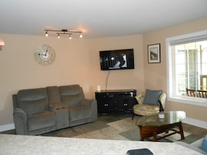 Living room with reclining love seat & couch. large flat screen on wall
