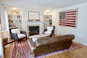 Enjoy the front living area, gorgeous RH leather couch and vintage flag!