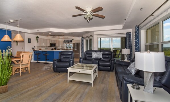 Dining table, chairs, sofas, ceiling fan, and breakfast bar