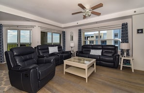 Living room with sofa, armchairs, and ceiling fan