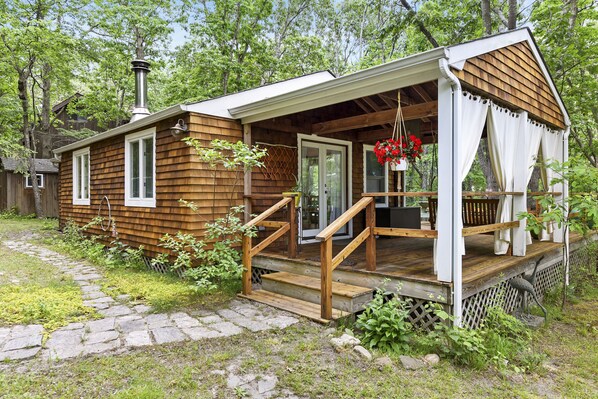 Main entrance to the cottage. Porch with bench swing 