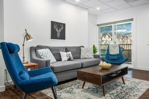 Spacious living room with pull-out sofa bed, 2 chairs and wall mounted 42" flat screen TV.  Satellite TV feed provides plenty of shows to choose from.