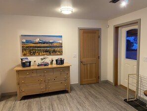 View of entry door w/dresser and shoe rack