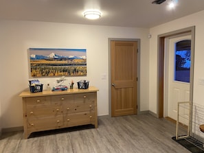 View of entry door w/dresser and shoe rack