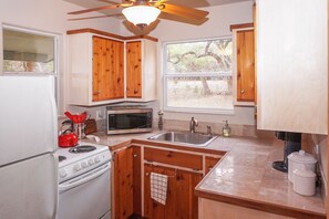 Small galley kitchen with range, oven, microwave, and refrigerator.