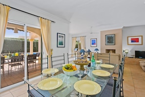 Dining area with ample seating,  patios doors lead out to garden and pool
