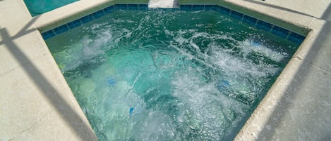 Bubbling spa with waterfall spillover into the pool.