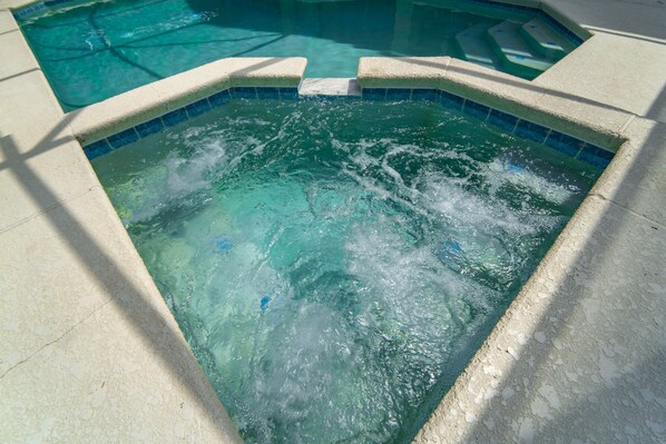 Bubbling spa with waterfall spillover into the pool.