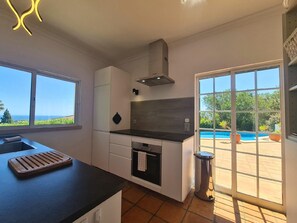Fully equipped kitchen with sea and pool view