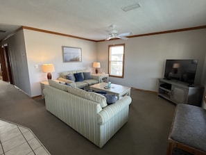 Living room w/a 48-inch TV with DVD player, DVD selection, books and games
