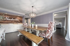 The dining room is one of the many places to sit and eat in this spacious home. Equipped with a wet bar for serving food and drinks and a stylish barn wood accent wall.