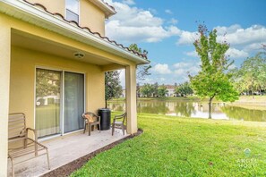 Back patio seating for outdoor dining with a big lawn area.