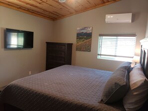 Master bedroom with king bed and large flat screen TV.