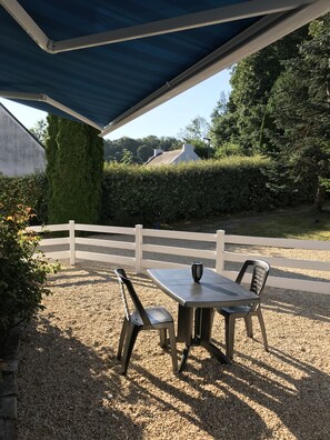 Petite terrasse sur jardin avec barbecue Weber