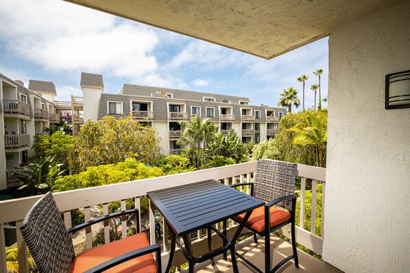 Relax on your private patio overlooking a running stream and lush greenery.