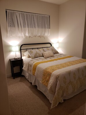 Queen Bed with black-out blind down; 2 night stands w/lamps