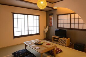 The living room has a TV, a safe and a sitting table.