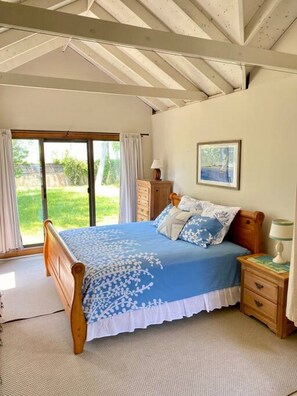 Dune Suite primary bedroom with King sleigh bed, sliders to yard and bunk beds (not shown).