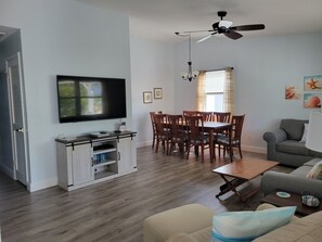Open living room and dining area with vaulted ceilings.